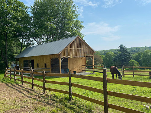 Finished horse barn connected to a fenced in pasture