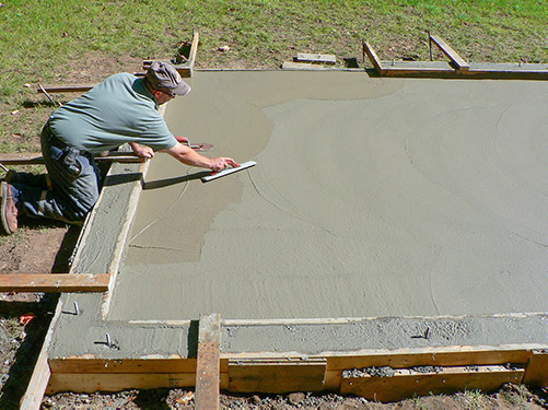 Skimming the freshly poured concrete slab to create a smooth and even surface